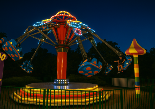 Atracția Tornado luminată noaptea, ride spectaculos cu scaune suspendate pentru copii și adulți într-un parc de distracții